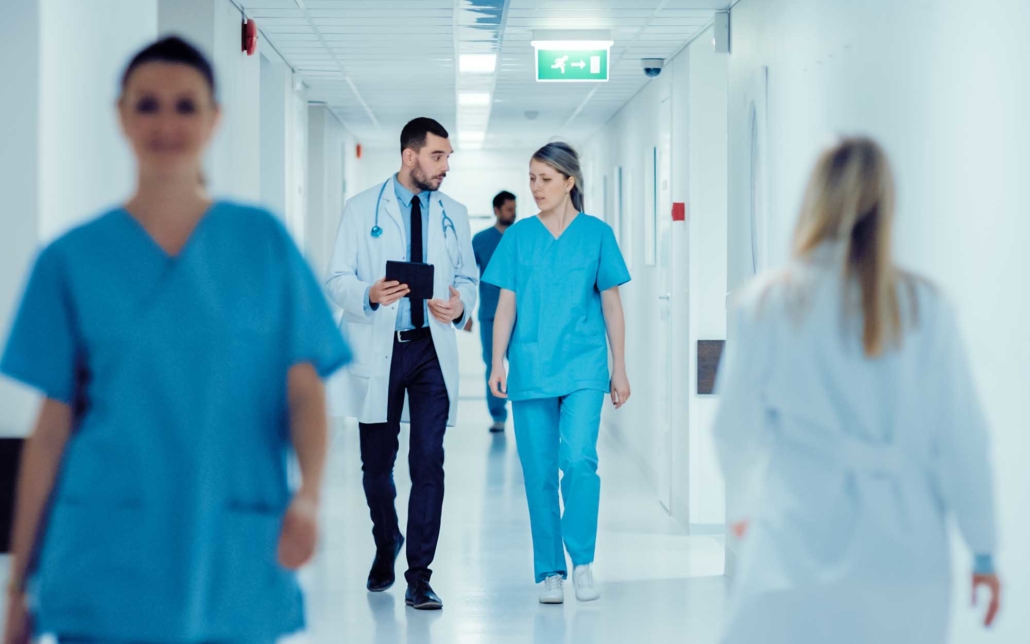 Two hospital workers walking down a hallway