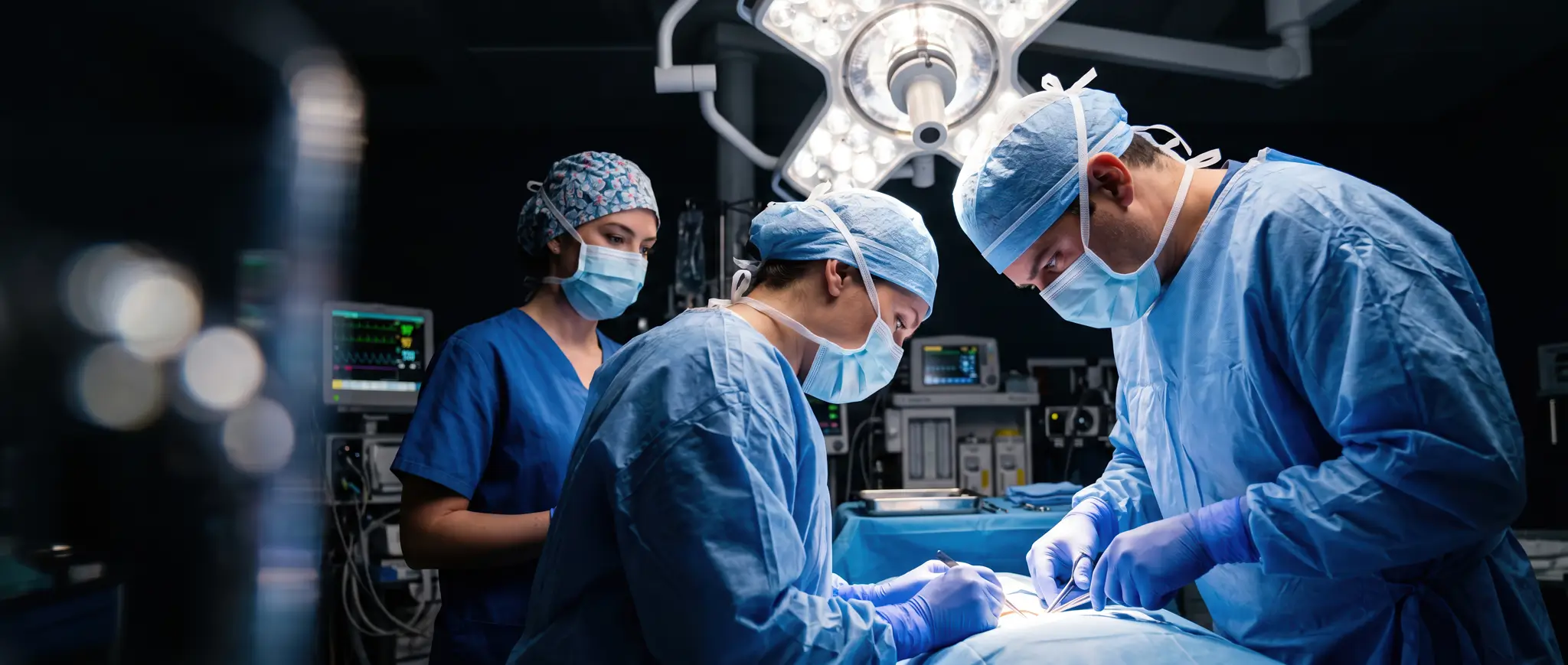 Surgical team operating under overhead lights