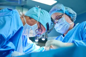 Two surgeons in blue scrubs focused on performing a surgical procedure in an operating room.